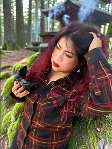 Divided Flannel Womens Hannya Flannel -  Woman in a plaid shirt with red hair and red lipstick standing in a forest.