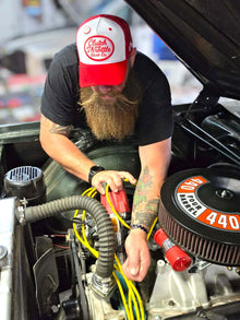 Red and white trucker at car engine