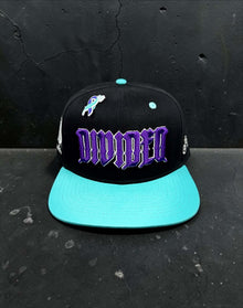 Front view of black Divided Flannel Co. YANA snapback with teal brim