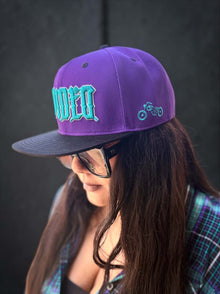 Women’s YANA bamboo short sleeve shirt with purple Divided YANA snapback close-up